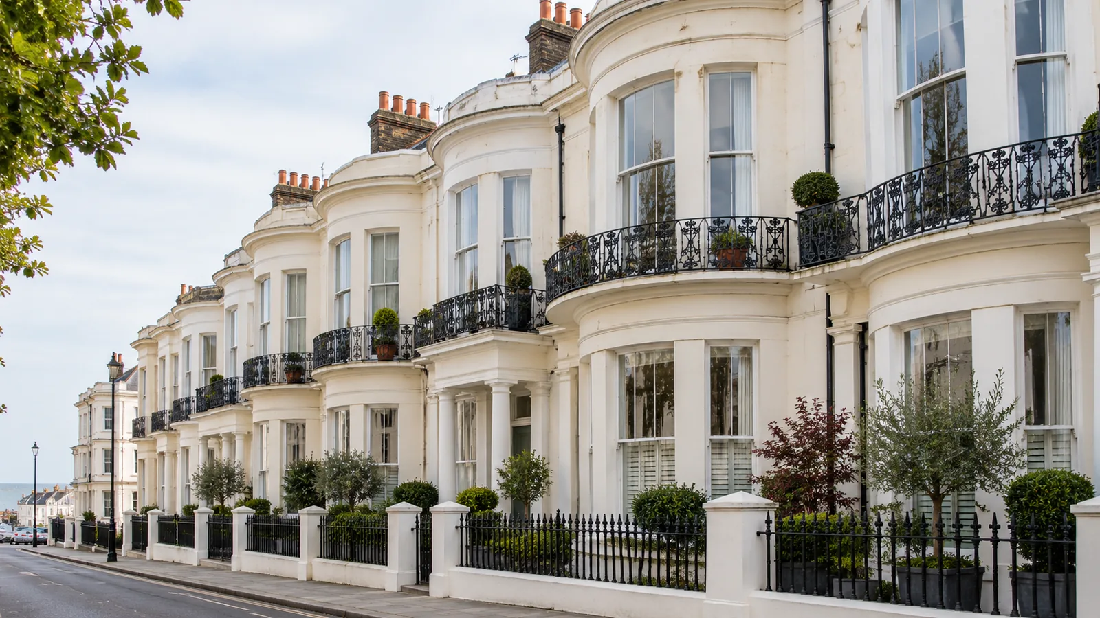 Cream stucco Regency townhouses with bow fronts and white sash windows